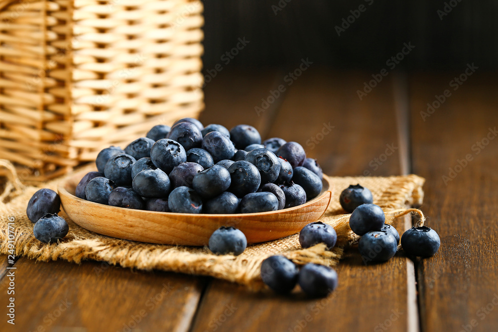 Fresh blueberries in wooden plate on a wooden table Fresh blueberries in wooden plate on a wooden table