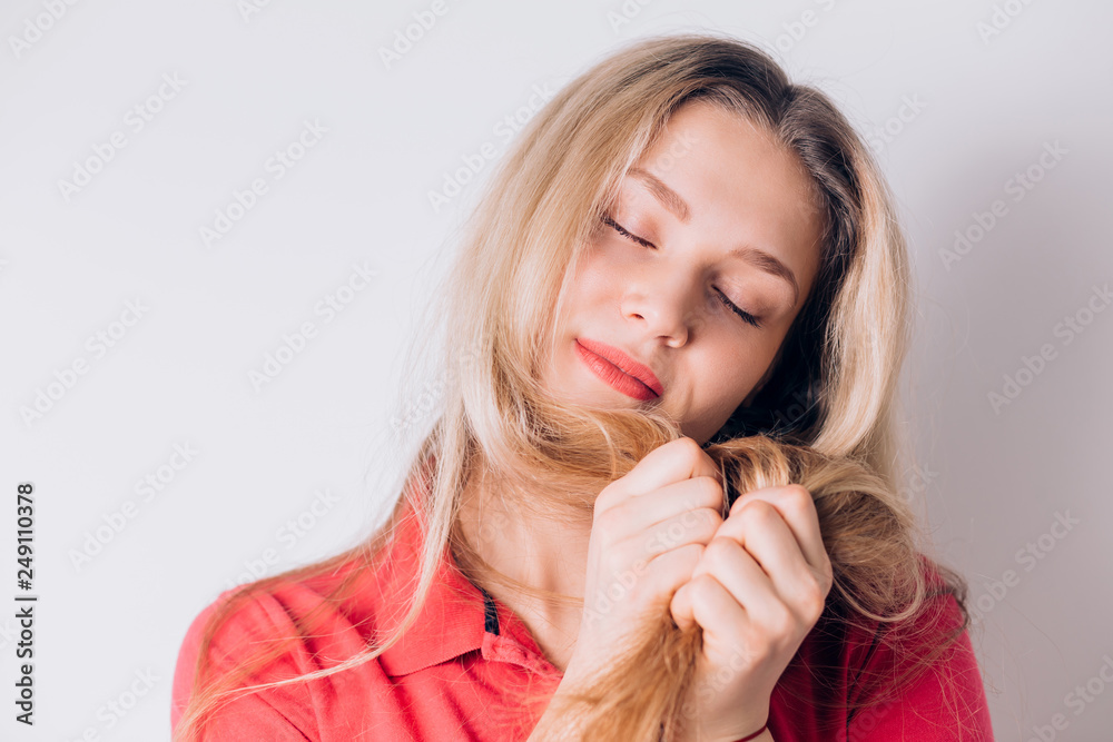 Gentle smiling blonde woman closes her eyes and dreams of something, thinks on a white background, close-up portrait Gentle smiling blonde woman closes her eyes and dreams of something, thinks on a white background, close-up portrait