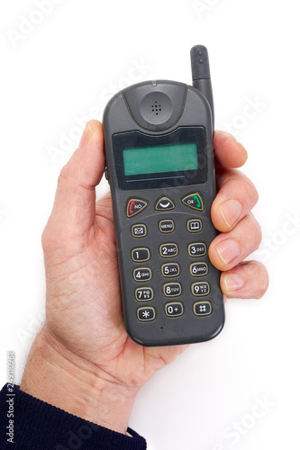 Hand holding a retro cell phone from the late 90's. Isolated on completely white background..
