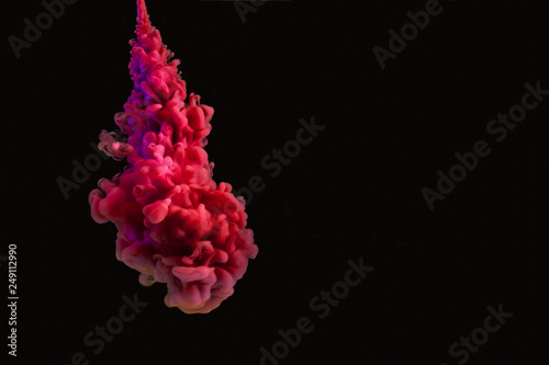 Coral texture red acrylic paint in water isolated on black. Abstract background for design.