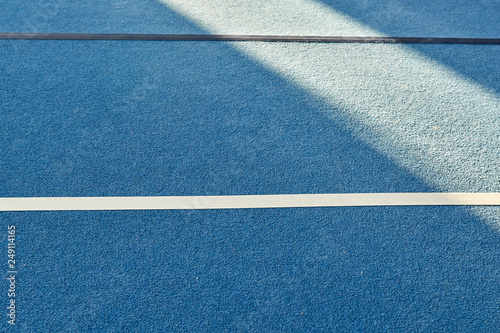 Colorful gym floor with diagonal color blocks. Background texture. Blue, black, white and yellow colors. Exercise concept, indoors sports, gymnastics. Morning sun.