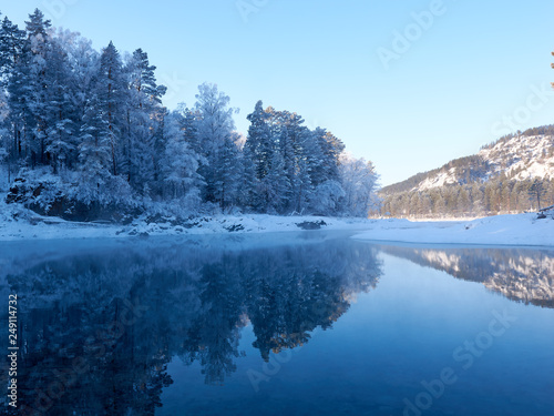 fabulous view in the mountains forest lake in the mirror reflection of the blue sky. Sunny Clear winter day. walk in the fresh air. nature.
