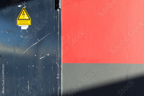gelbes Warnschid TECHNISCHER BETRIEBSRAUM in gelb auf schwarzer Metalltür un Wand in rot und schwarz geeignet als Hintergrund mit Textfeld