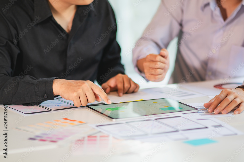 Business partners use tablet discussing documents and ideas at meeting. Business partners use tablet discussing documents and ideas at meeting.