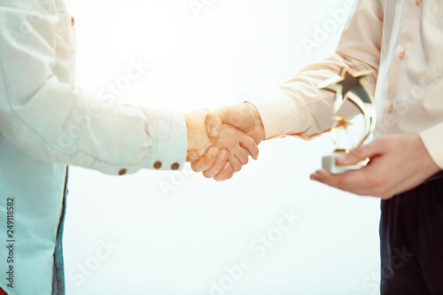 Handshake. Boss approving and congratulating young successful employee of the company for his success and good work. National Employee Appreciation Day concept.