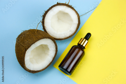 coconut and oil bottle on a yellow and blue background