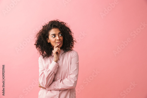 Happy beautiful young african woman posing isolated over pink wall background.