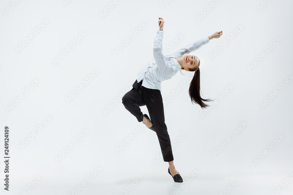 Happy businesswoman dancing and smiling in motion isolated on white studio background. Flexibility and grace in business. Human emotions concept. Office, success, professional, happiness, expression Happy businesswoman dancing and smiling in motion isolated on white studio background. Flexibility and grace in business. Human emotions concept. Office, success, professional, happiness, expression