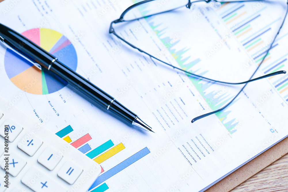 pen,glasses and calculator on Financial accounting stock market graphs analysis chart pen,glasses and calculator on Financial accounting stock market graphs analysis chart