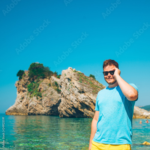 standing man with blue clear sea water on background