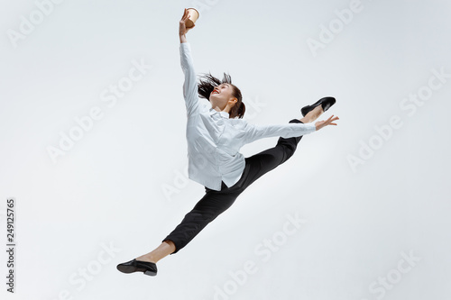 Happy businesswoman dancing and smiling in motion isolated on white studio background. Flexibility and grace in business. Human emotions concept. Office, success, professional, happiness, expression