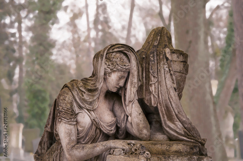 Sculpture of sad woman in grief. Virgin Mary stone statue (faith, suffering, death concept)