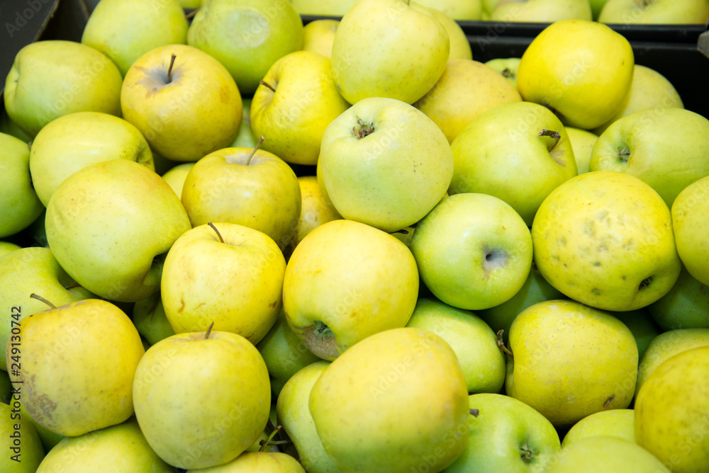 fresh fruit, many ripe apples on the counter in the supermarket