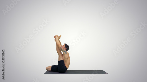 Male yoga teacher in heron pose Intense hamstring stretch Flexibility, well being concepts on gradient background. photo