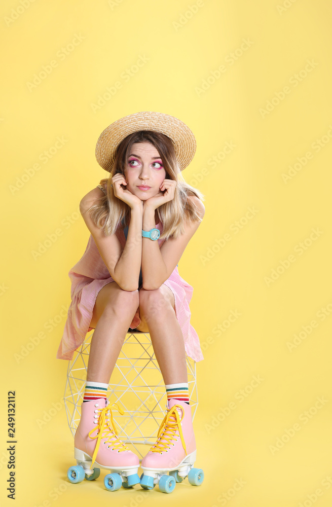 Young woman with retro roller skates on color background Young woman with retro roller skates on color background