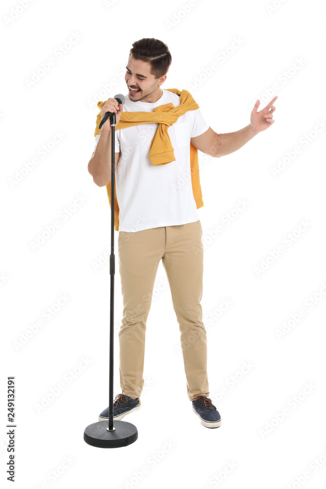 Fototapeta premium Young handsome man in casual clothes singing with microphone on white background
