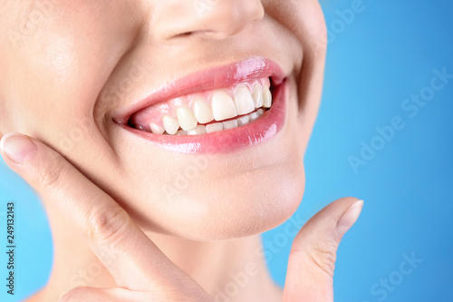 Young woman with healthy teeth and beautiful smile on color background  closeup
