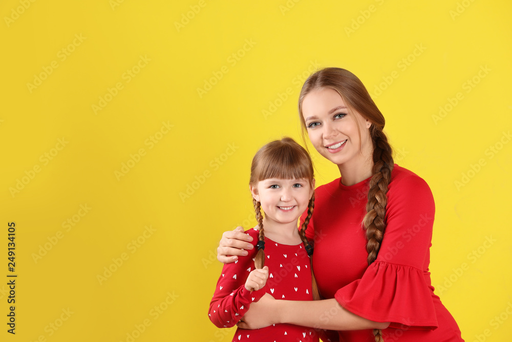 Happy woman and daughter in stylish clothes on color background, space for text Happy woman and daughter in stylish clothes on color background, space for text