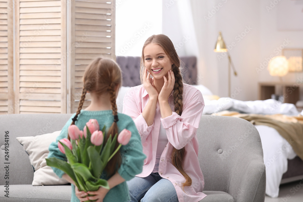 Happy mother and daughter with flower bouquet at home. International Women's Day Happy mother and daughter with flower bouquet at home. International Women's Day