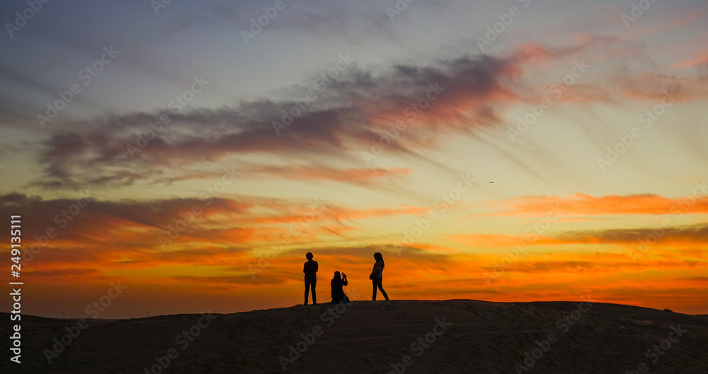 Young people enjoying the sunset on desert