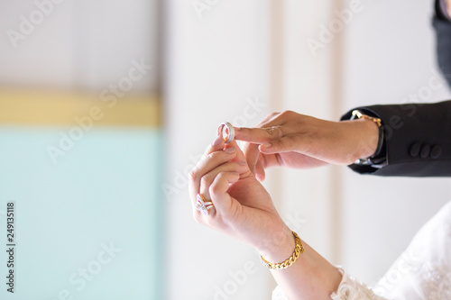 Couple wearing wedding ring in celebration matrimony,Concept: symbol relationship romantic married to be happy,The groom wears a bridal ring