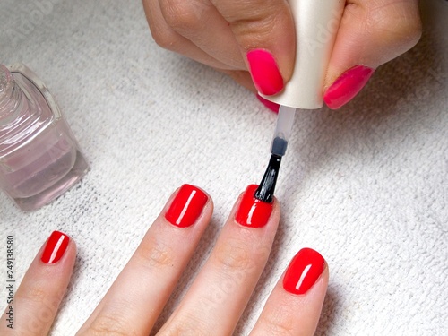 Close-up of girl painting red polish on her nails