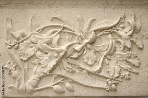 Beautiful white Java stucco patterned on the boundary wall. Vintage white wall bas-relief stucco in plaster, depicts Lotus flowers background. photo