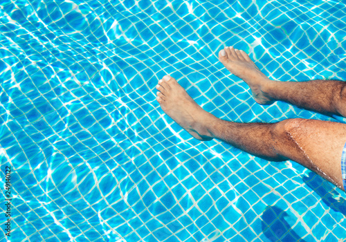 Men's feet in the pool