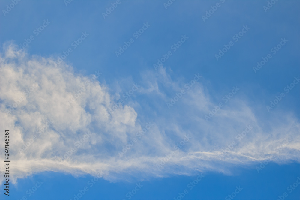 Sparse clouds in the blue sky morning background. Fluffy clouds in the blue sky evening background. Blue sky in summer background with tiny clouds,