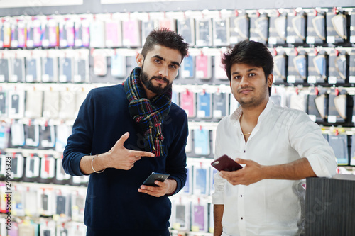 Two indians mans customer buyer at mobile phone store with them new smartphones. South asian peoples and technologies concept. Cellphone shop.