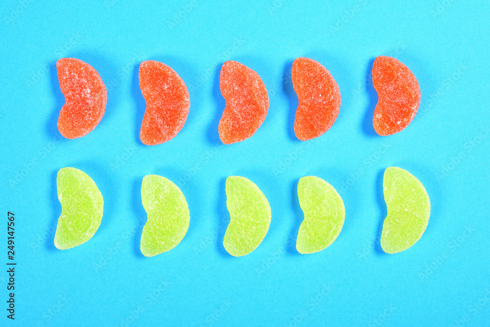 group of jelly candies piece of orange fruit color yellow and orange on blue background group of jelly candies piece of orange fruit color yellow and orange on blue background