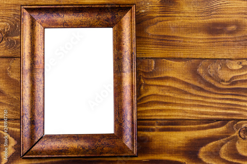 Empty photo frame on wooden background. Top view