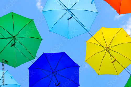 colorful umbrellas  white  blue  green  red and yellow against the background of the summer sky  umbrellas of different colors from the sun