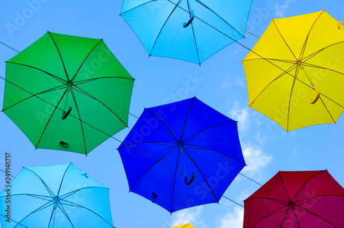 colorful umbrellas  white  blue  green  red and yellow against the background of the summer sky  umbrellas of different colors from the sun