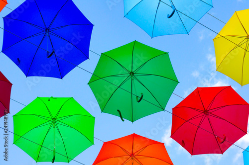 colorful umbrellas  white  blue  green  red and yellow against the background of the summer sky  umbrellas of different colors from the sun