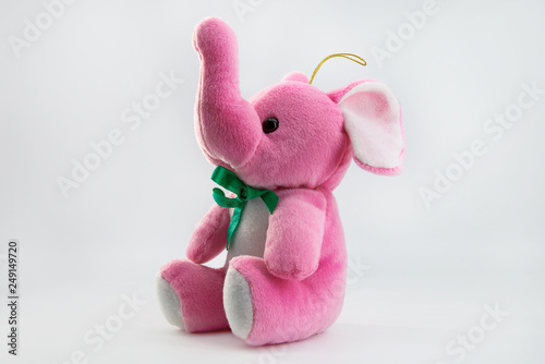 Soft toy pink elephant sitting isolated on white background.  photo