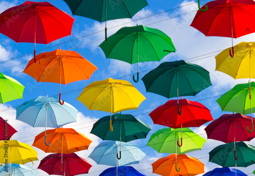 colorful umbrellas  white  blue  green  red and yellow against the background of the summer sky  umbrellas of different colors from the sun