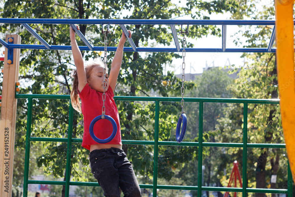 A girl climbs the stairs on the playground in the park