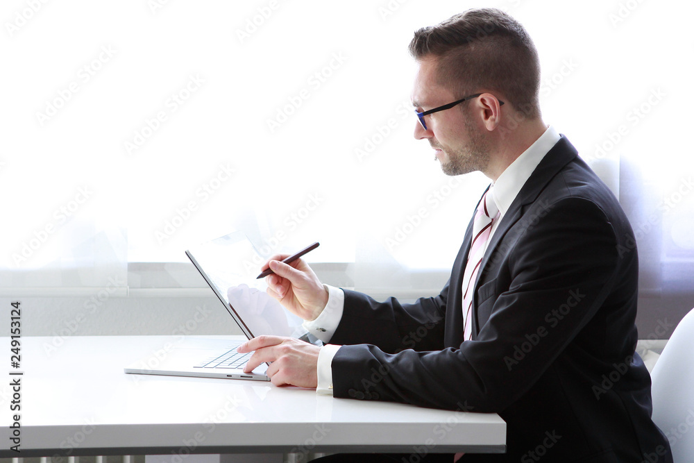 Geschäftsmann sitzt am Tisch mit Tablet und schreibt auf dem Display Geschäftsmann sitzt am Tisch mit Tablet und schreibt auf dem Display