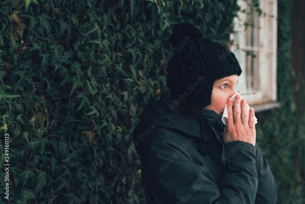 Woman blowing her nose into paper handkerchief Woman blowing her nose into paper handkerchief