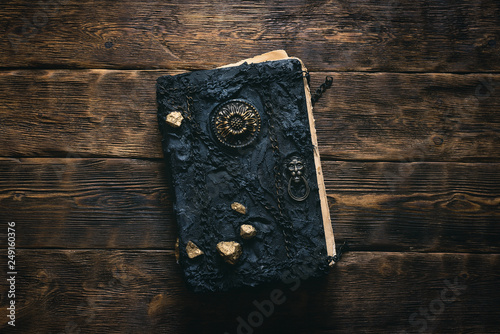 Fotografie Ancient magic book on a wooden table background. Spellbook.