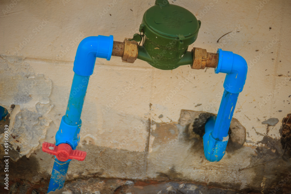 Vintage water meter installed with bronze joint, PVC elbow connector