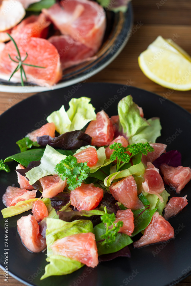Healthy green salad with grapefruit, lose weigh food. Diet plan. Wooden rustic table.