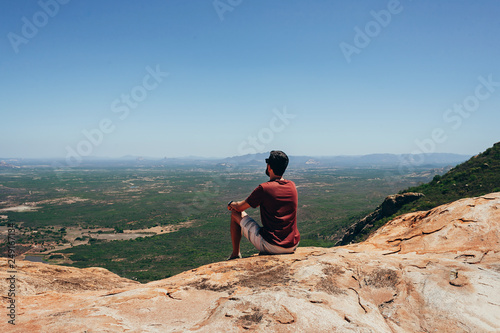 Man on top of mountain enjoying the scenery. Concept of freedom
