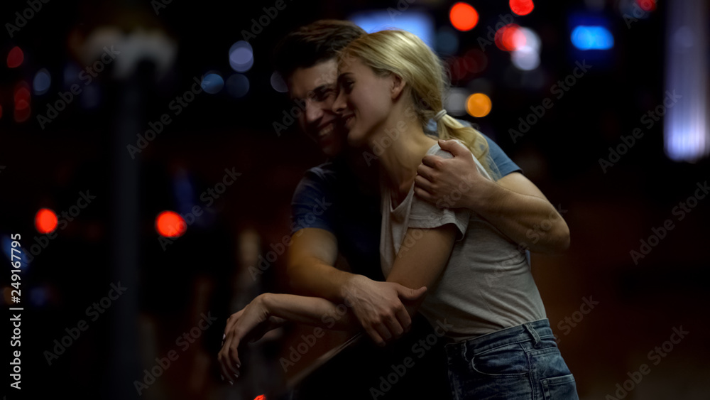 Happy young couple in love talking and hugging on city street at night, romance Happy young couple in love talking and hugging on city street at night, romance