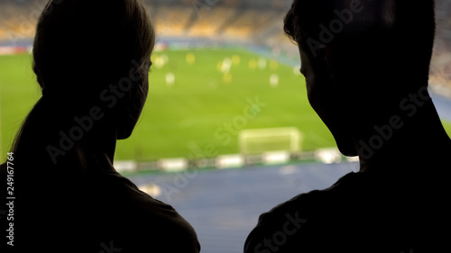 Couple of football fans having romantic date at stadium, cheering national team