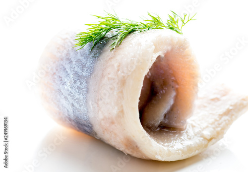Fotografie peeled fish fillet on a white background with the decor of greens and onions