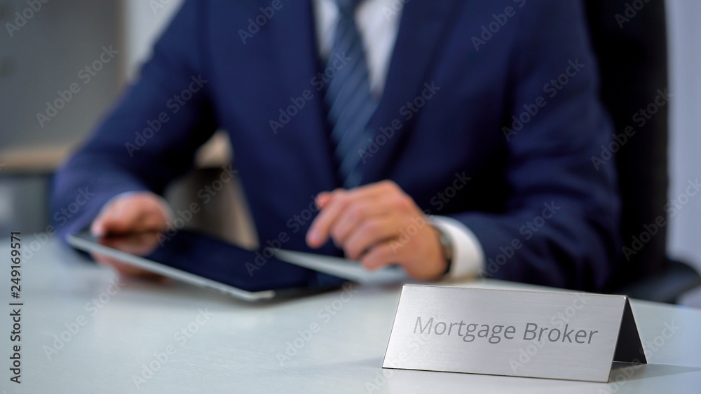 Mortgage broker working on tablet pc, searching for best real estate offer Mortgage broker working on tablet pc, searching for best real estate offer