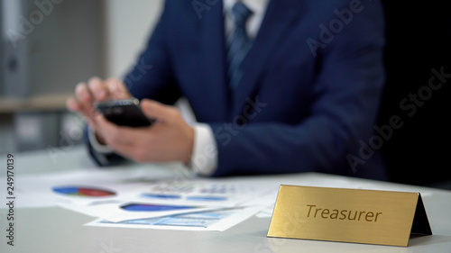 Canvas Print Government treasurer working on financial documents with smartphone in hands