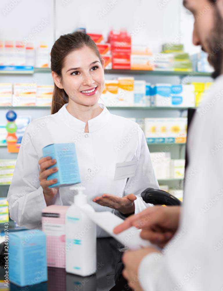 Woman pharmacist is recommending medicine for man client in apothecary.